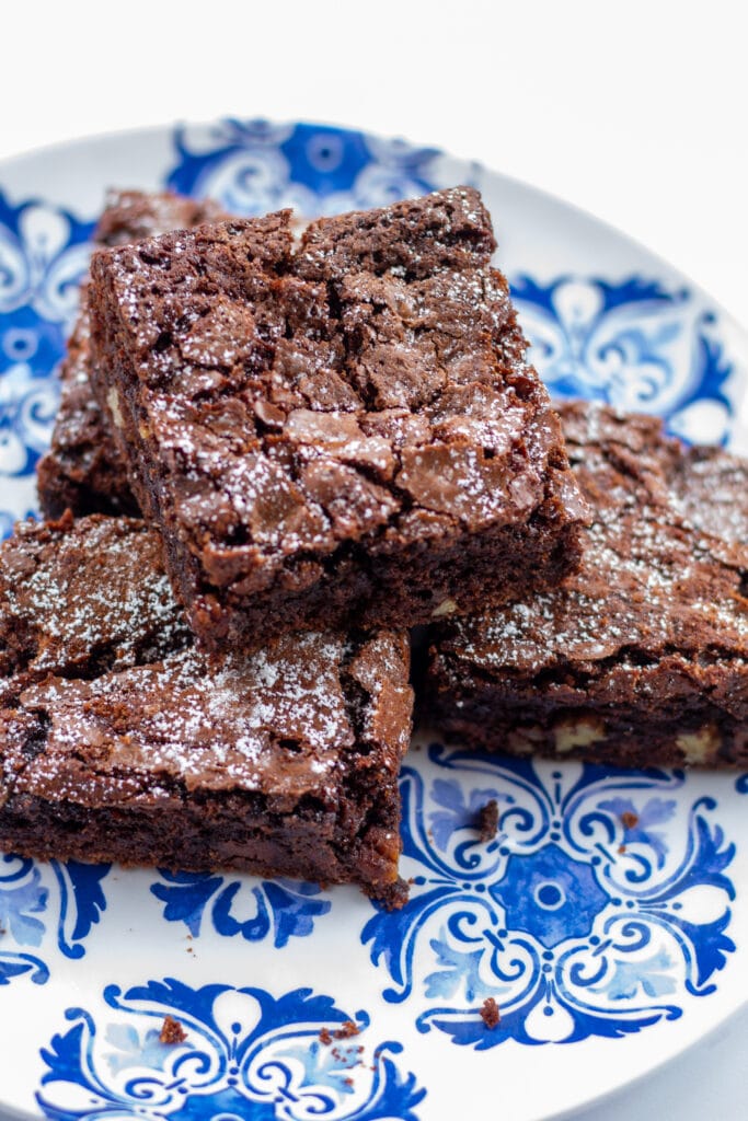 four brownies stacked on a blue plate