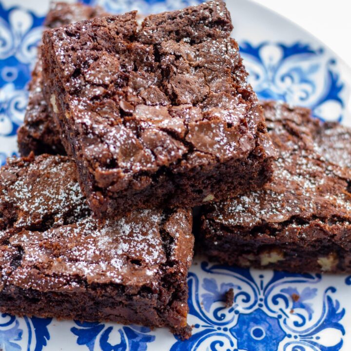 four brownies stacked on a blue plate