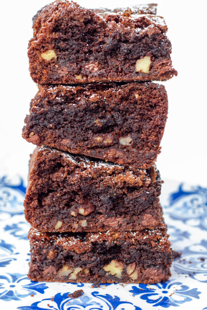 four brownies stacked high on a blue plate