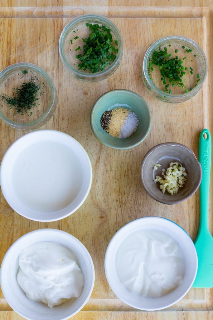 ranch dressing ingredients in separate bowls on a cutting board