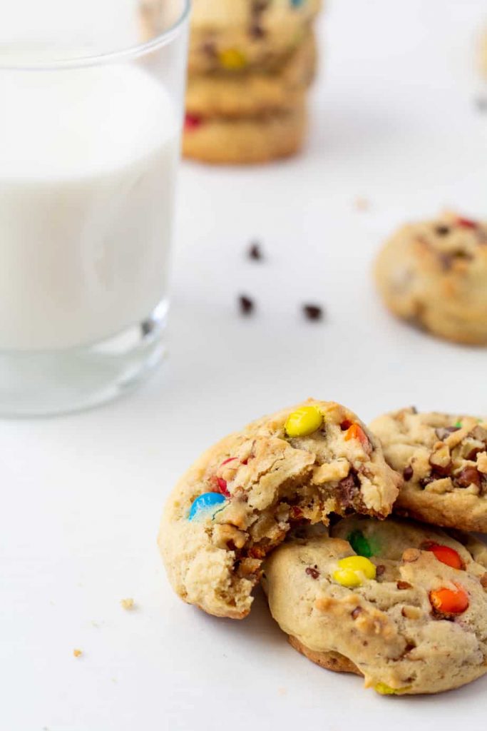 chocolate chip cookies on a white background with a glass of milk in the background