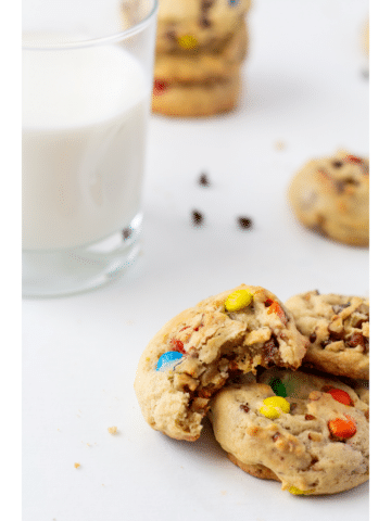 chocolate chip cookies on a white background with a glass of milk in the background