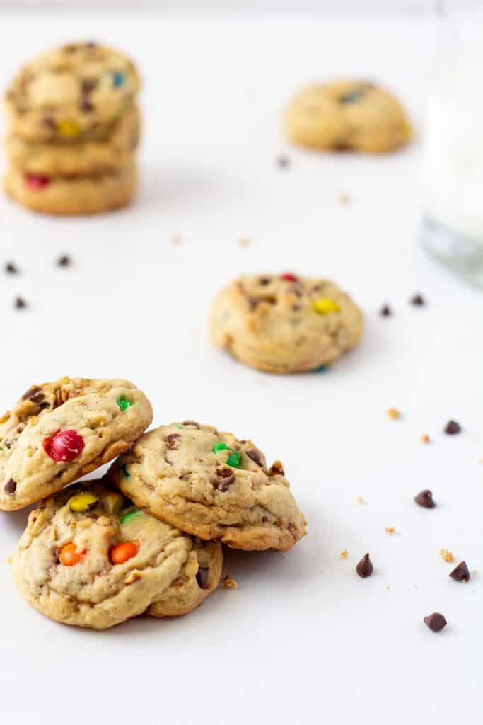 chocolate chip cookies on a white background with chips and cookies behind