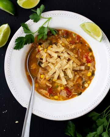 soup in a white bowl on a black background with a spoon