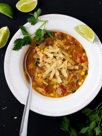 soup in a white bowl on a black background with a spoon