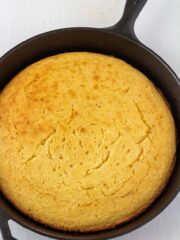 cornbread in a cast iron skillet on a white background