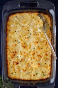 potatoes in a casserole dish on a dark background