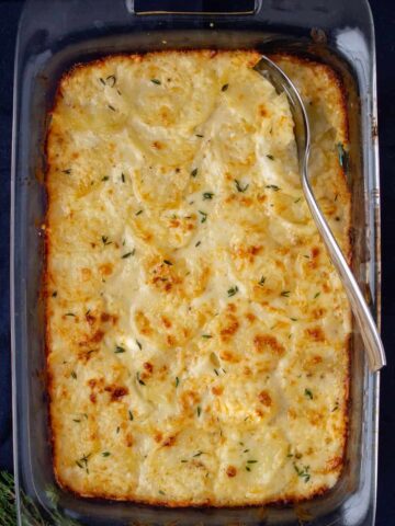 potatoes in a casserole dish on a dark background