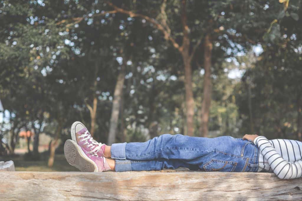 a woman laying down on a wooden fence while spending time at home 