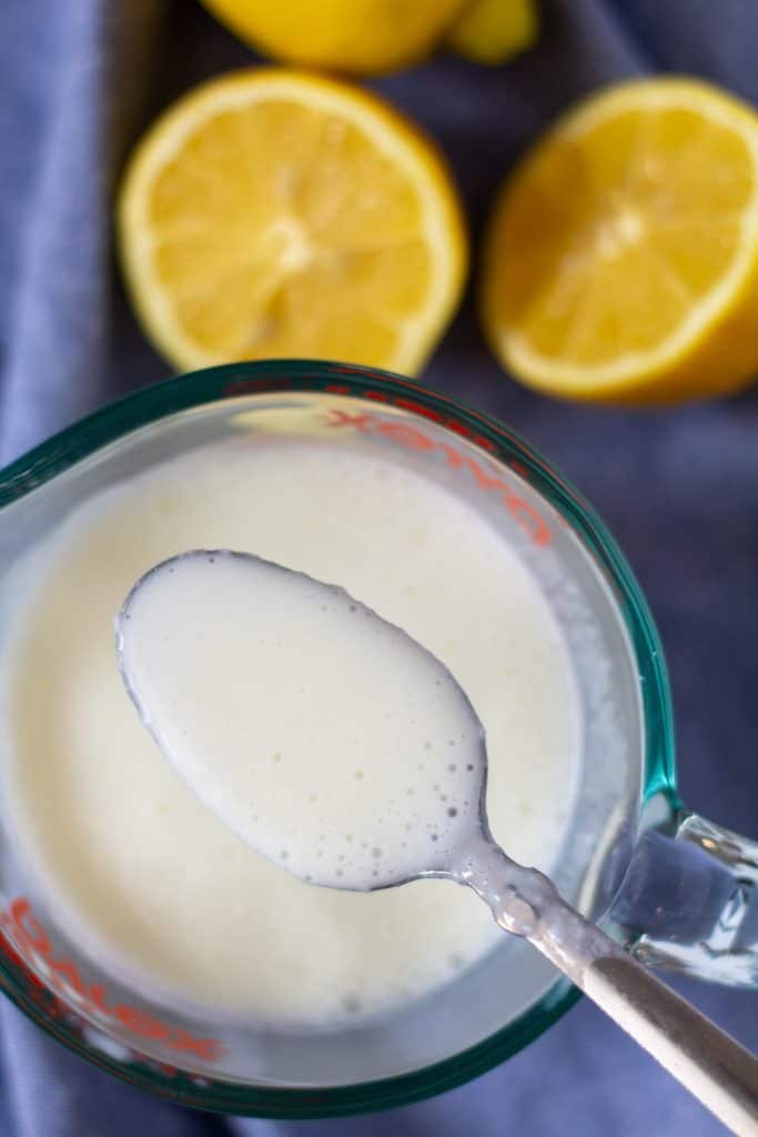 buttermilk on a spoon with cut lemons in the background