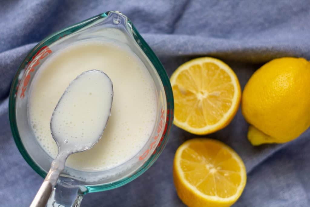 buttermilk on a spoon with cut lemons in the background