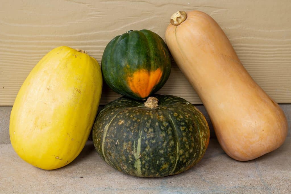 squashes stacked on top of each other with a tan background