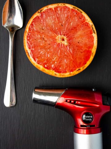 torch, spoon, grapefruit on black background