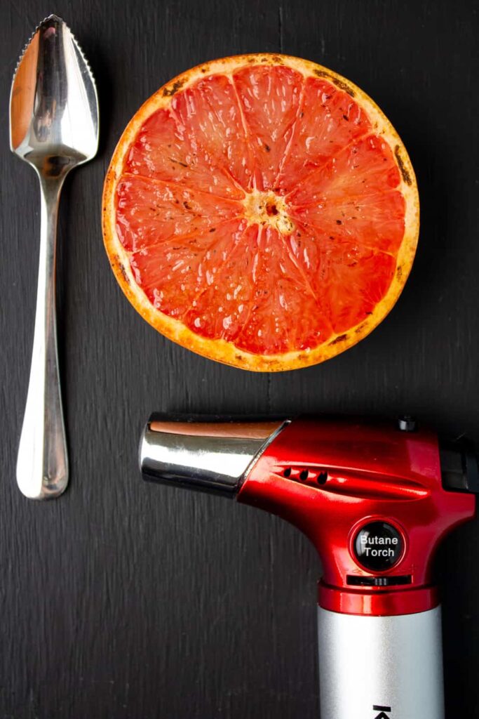 torch, spoon, grapefruit on black background