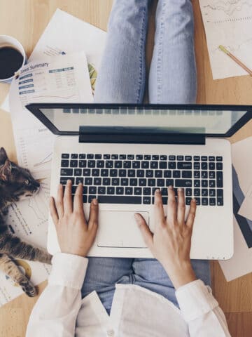 woman working on a computer sitting on the ground