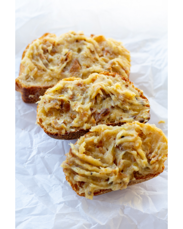 three pieces of bread with roasted garlic spread over the tops on a white background