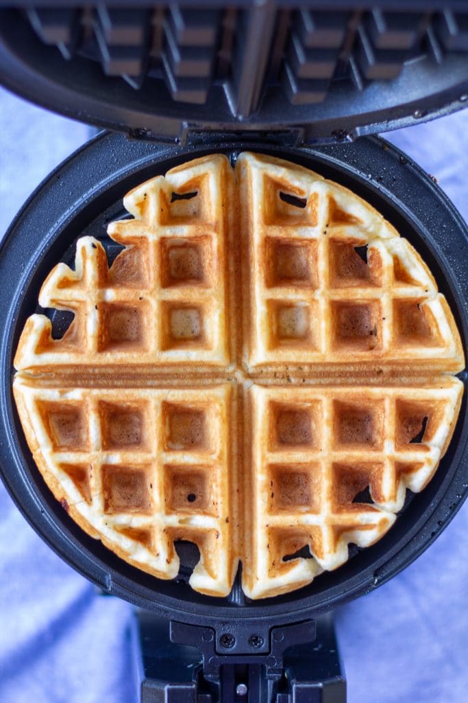 a waffle in an iron on a blue background