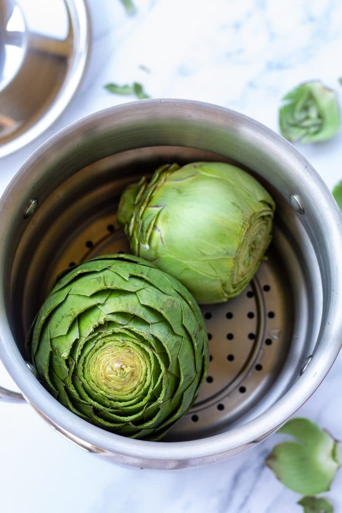 whole artichokes in a steamer