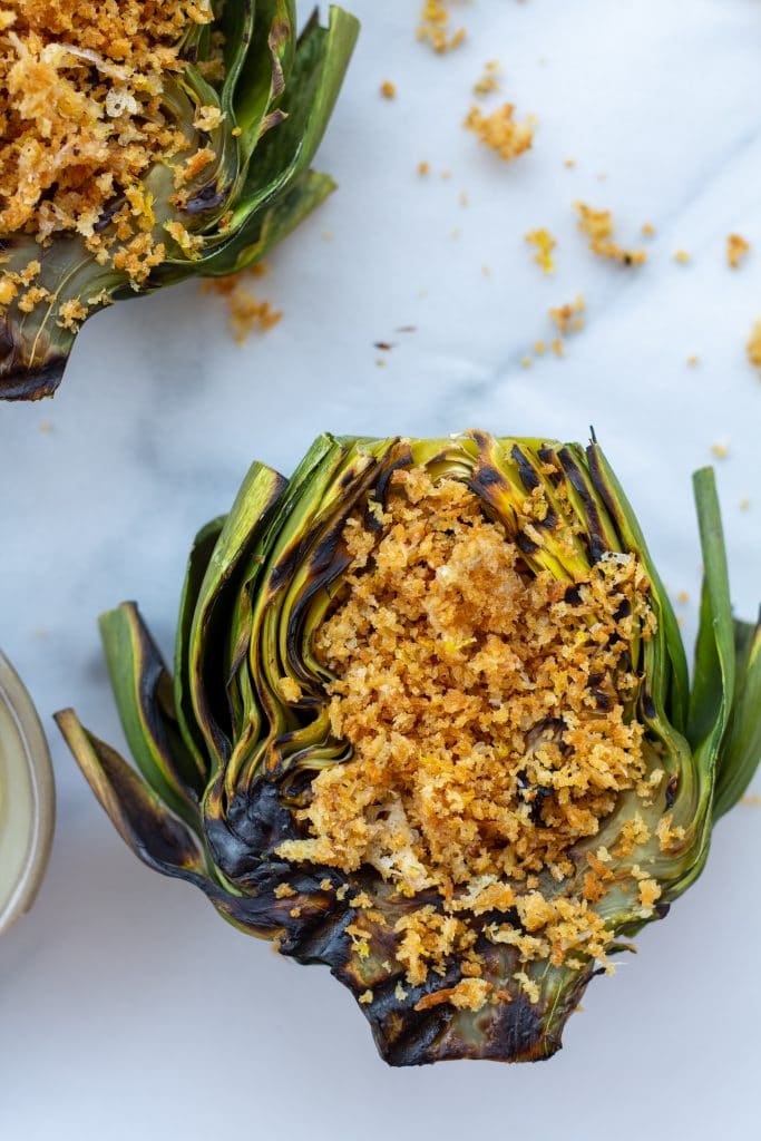 close up view of an artichoke with a parmesan panko topping