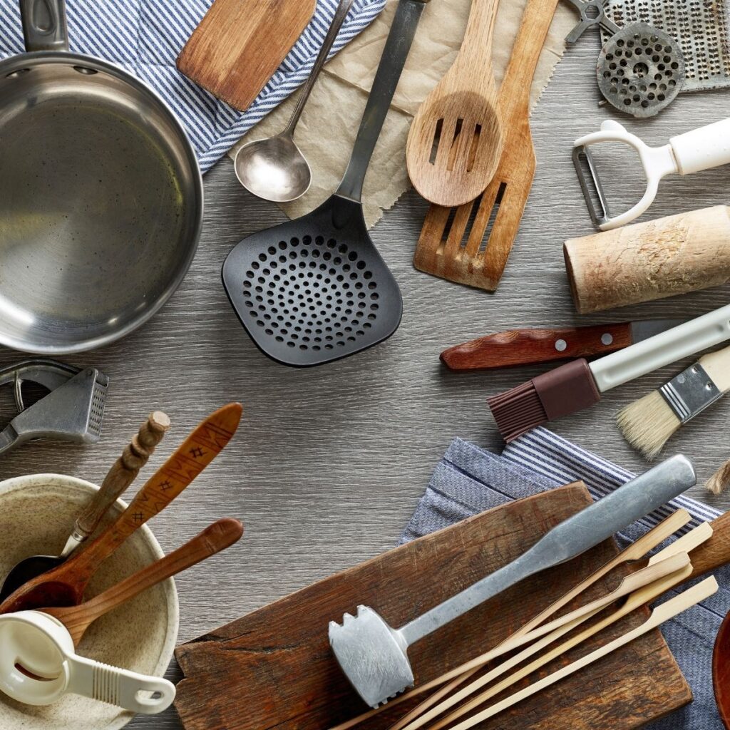 kitchen tools and utensils artfully arranged on a gray background