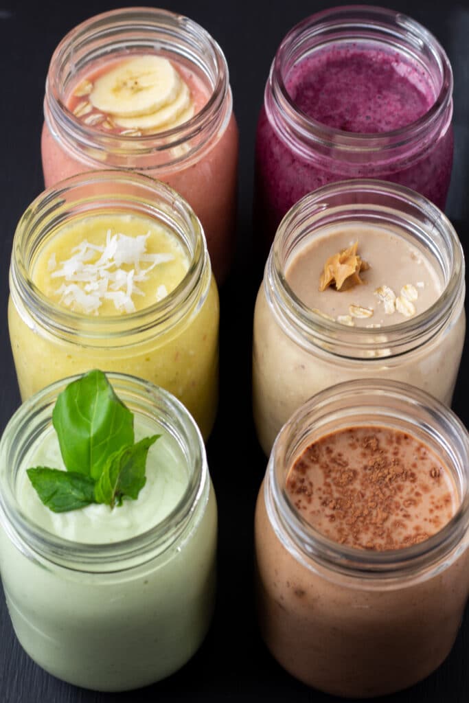 six easy breakfast smoothies lined up in a row on a black background