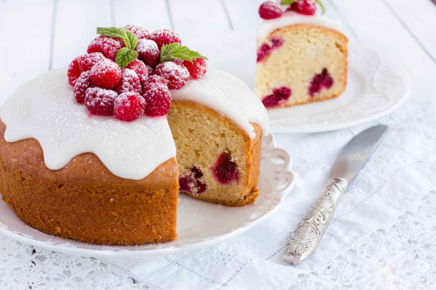 round coffee cake with white icing and berries on top