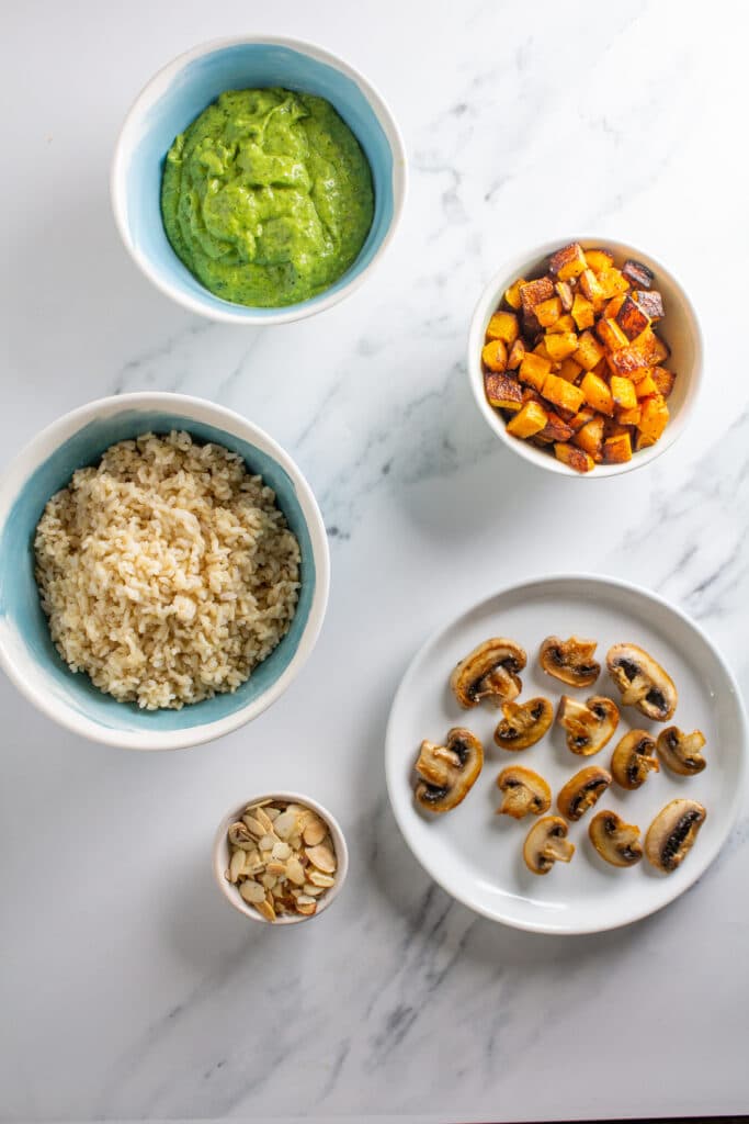 Plates and bowls of ingredients for the recipe on a white marble background