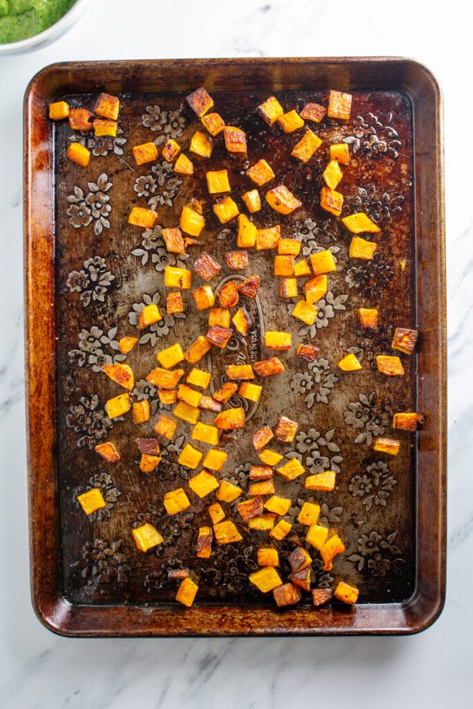 Roasted butternut squash on a weathered baking sheet