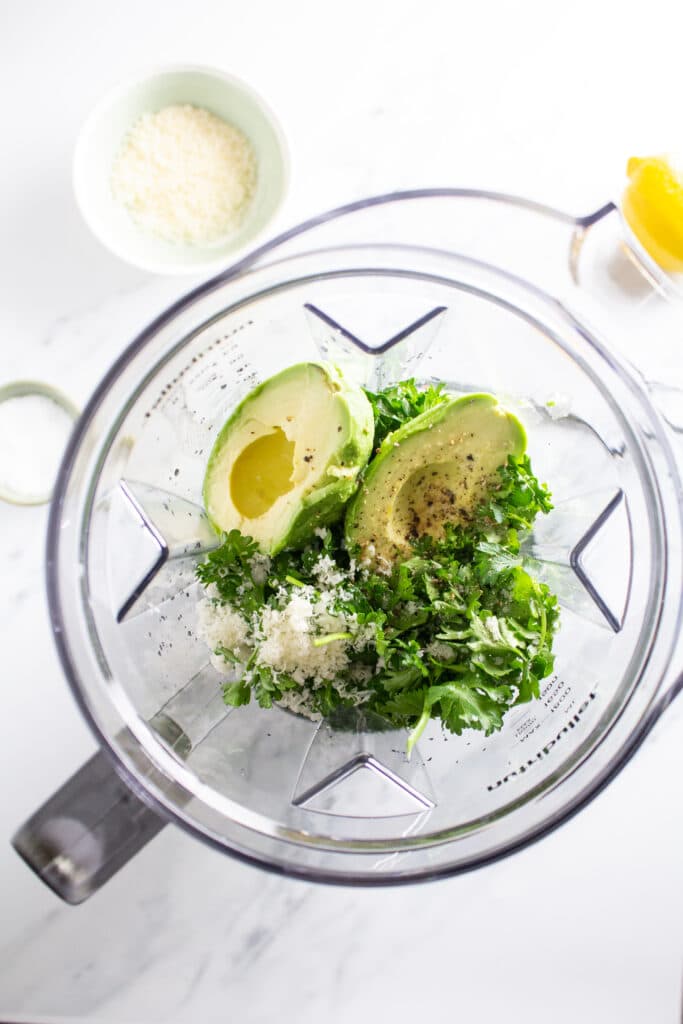 An overhead shot of ingredients for green sauce in a blender