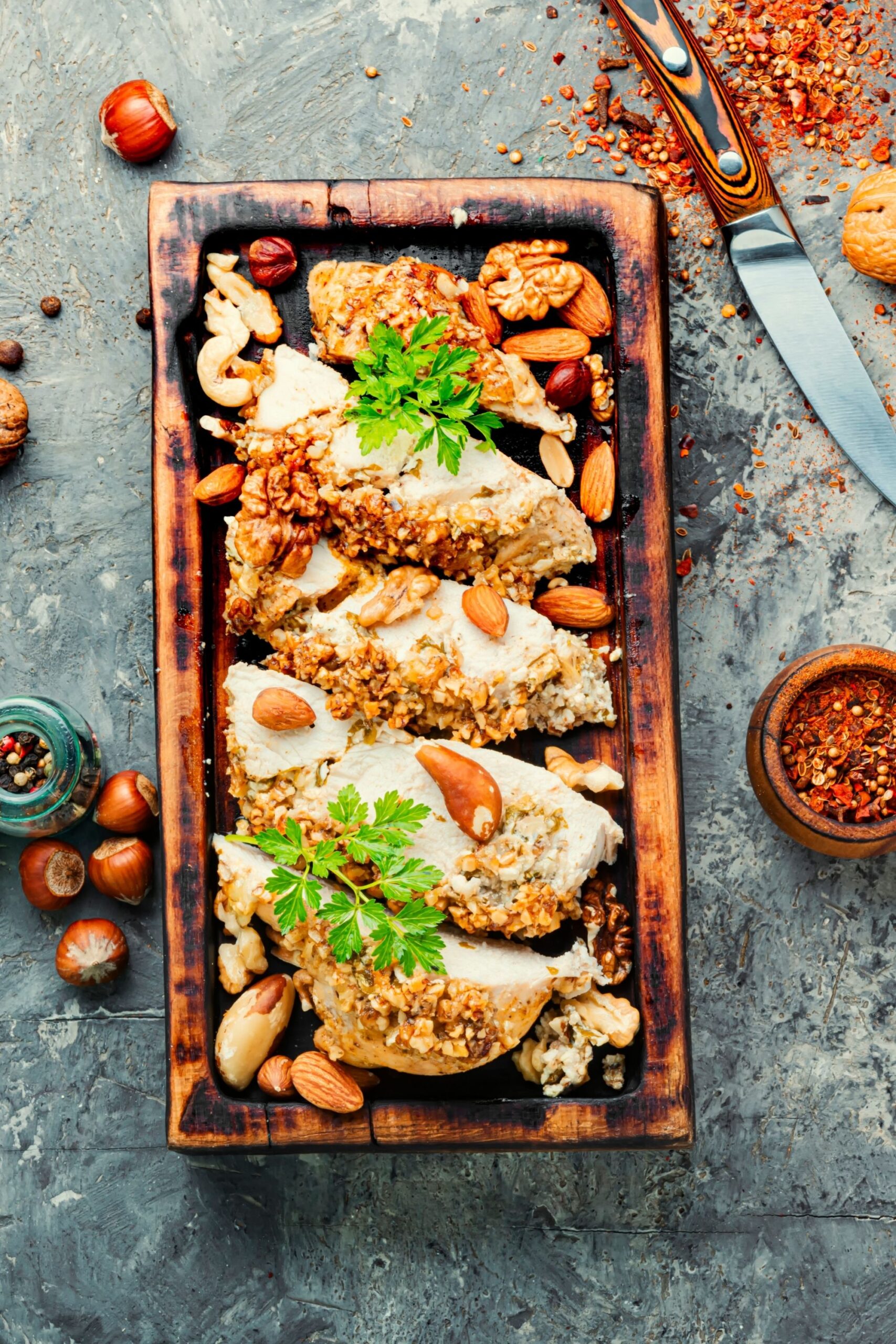 chicken breasted on a wooden board with crunchy nuts on top