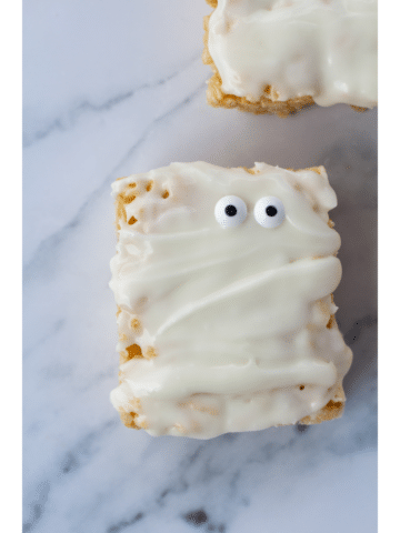 One mummy rice crispy treat with googly eyes on a white marble surface