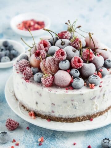 frozen cake with berries on top on a white plate