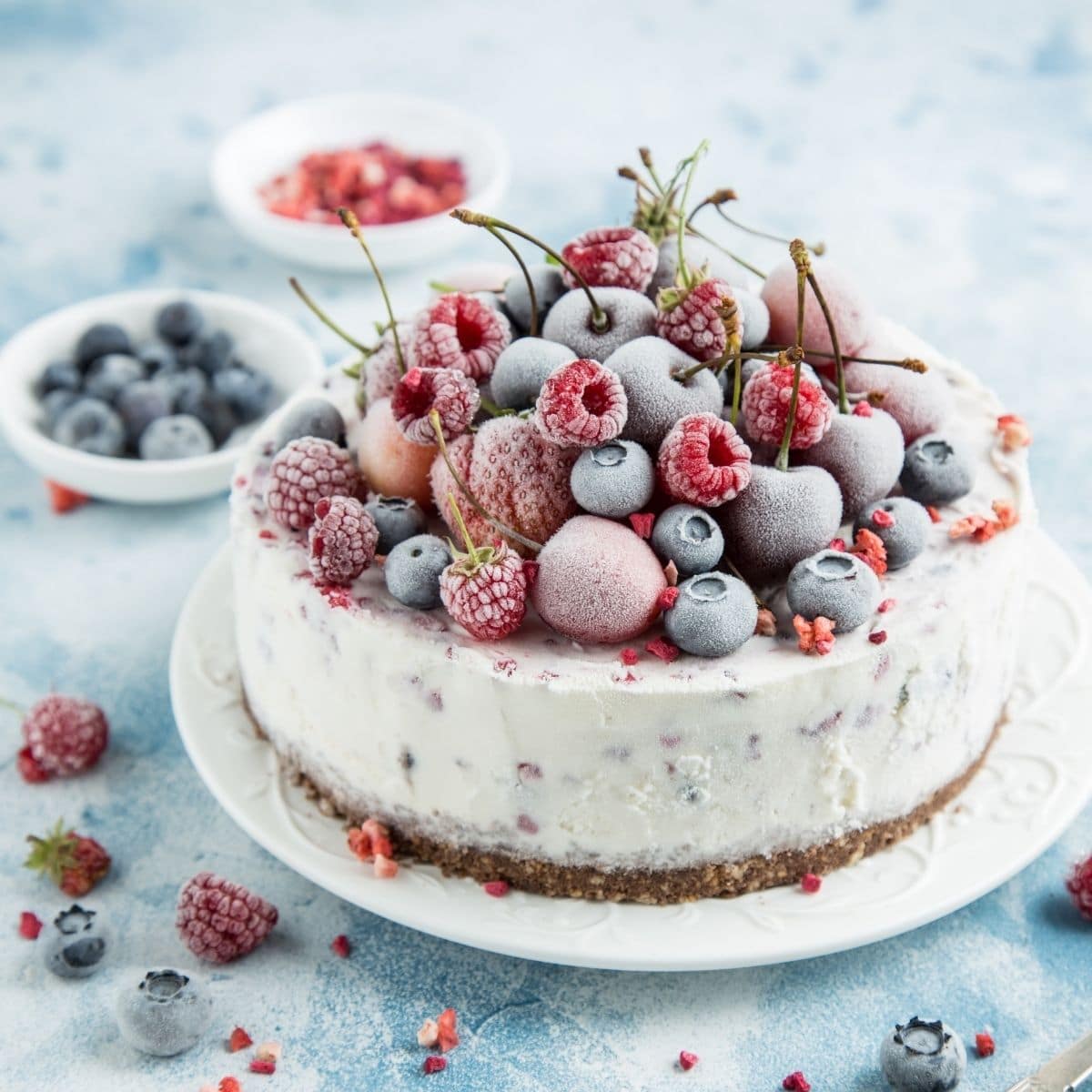 frozen cake with berries on top on a white plate