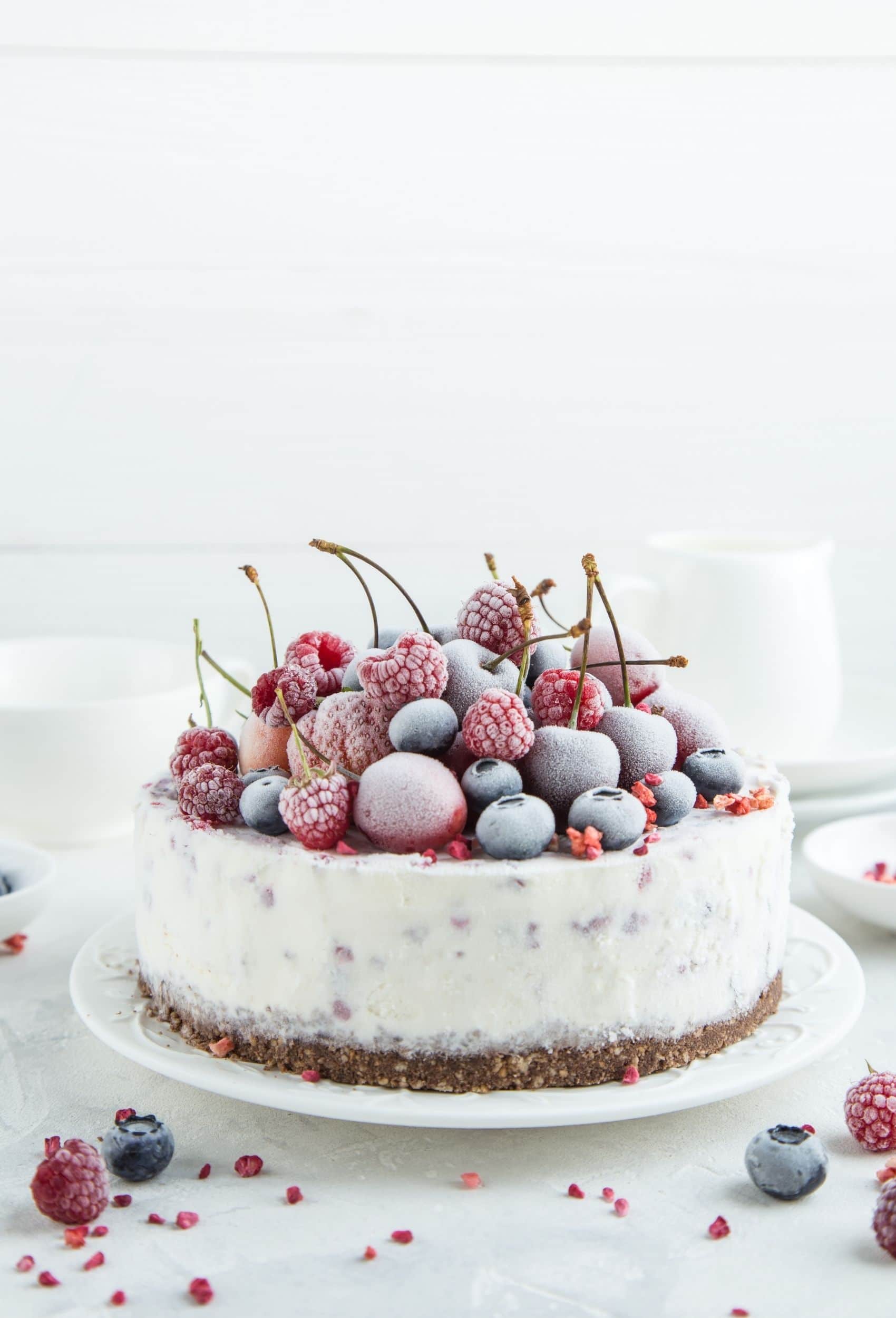 frozen cake with berries on top on a white plate