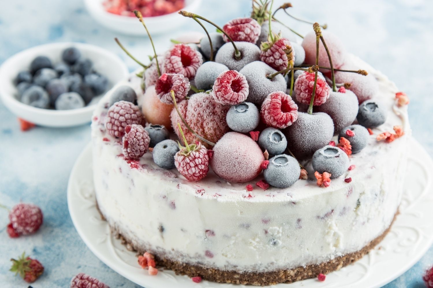 frozen cake with berries on top on a white plate