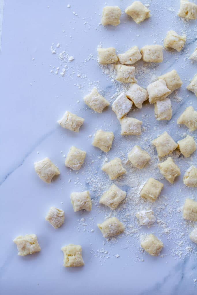 gnocchi spread out on a white marble counter