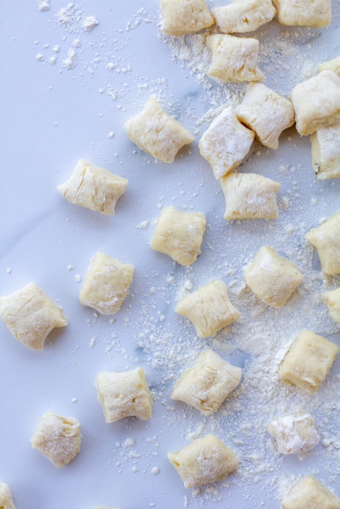 close up of gnocchi on a white marble counter