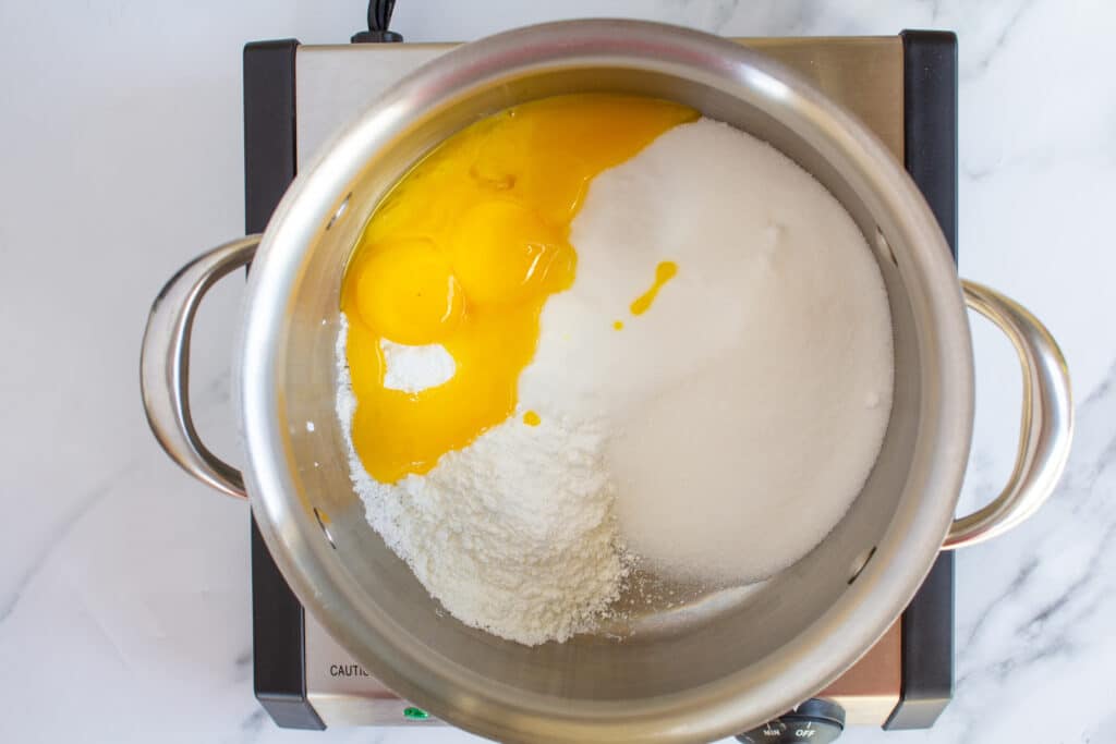 a pot with eggs, sugar, and cornstarch