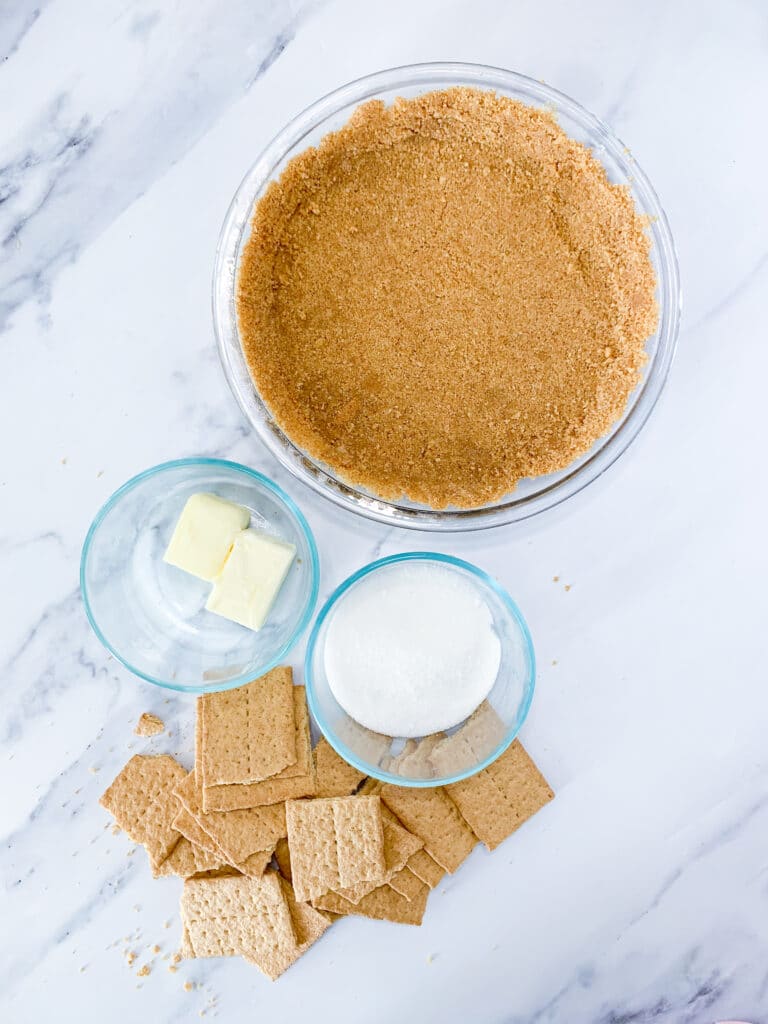 graham cracker crust ingredients sitting on a white marble background