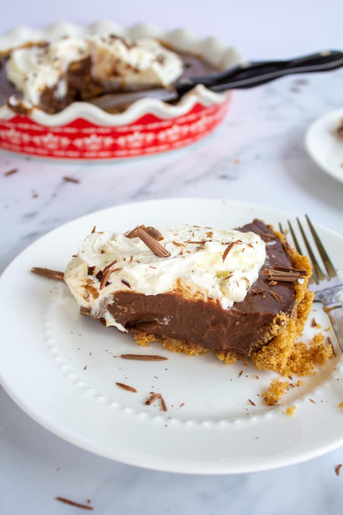 a piece of pie in center frame with the whole pie slightly behind and out of shot