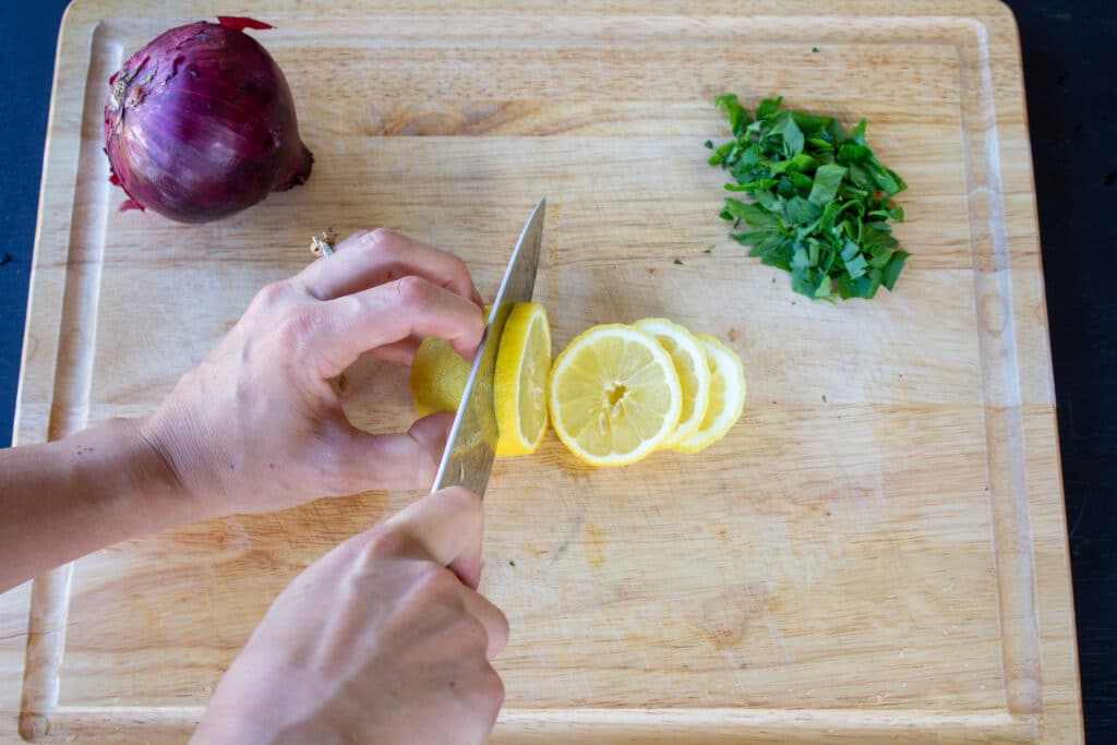 slicing lemon on a cutting board