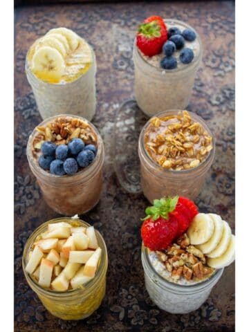 an overhead view of 6 jars of oats with toppings