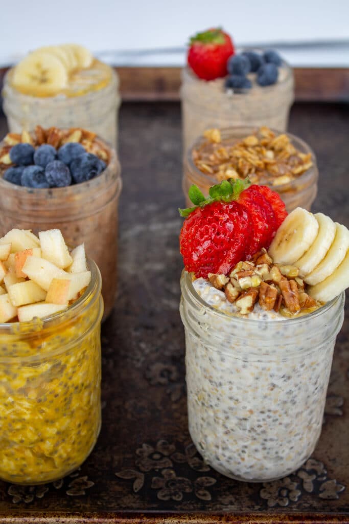 a side view of overnight oats in jars with different toppings