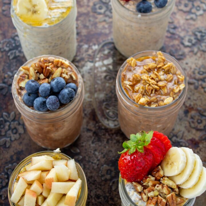 an overhead view of 6 jars of oats with toppings