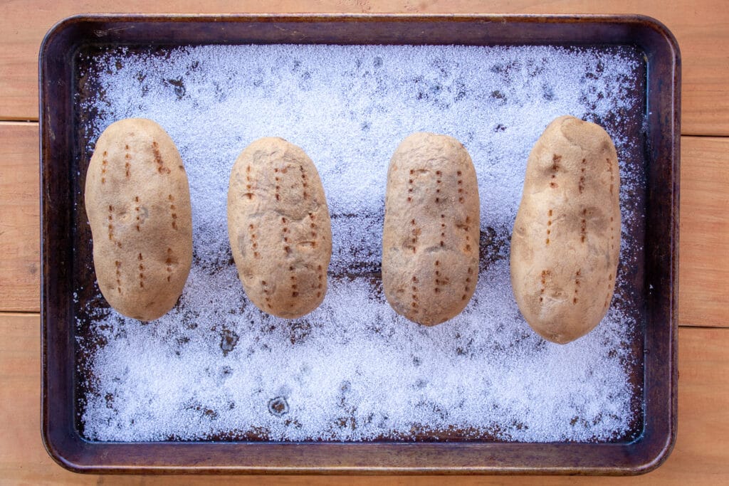 potatoes on a baking sheet filled with salt