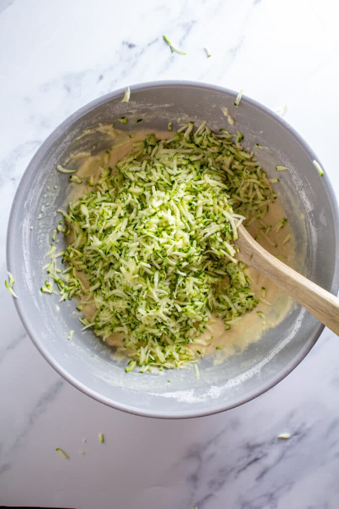 A bowl of batter with zucchini on top