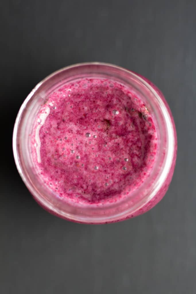 overhead view of a purple smoothie with honey drizzled on top