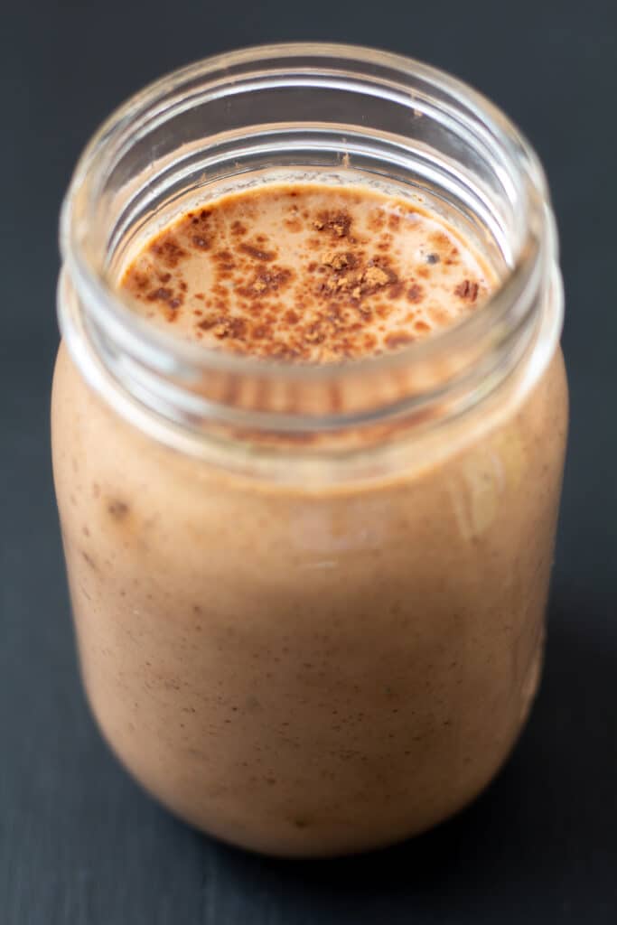 side view of a chocolate smoothie with cocoa powder on top