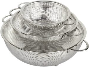 A set of three stainless steel colanders nested together