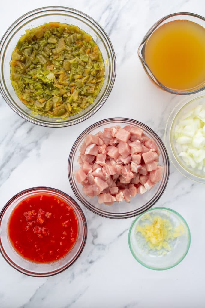 ingredients for green chile on a marble surface